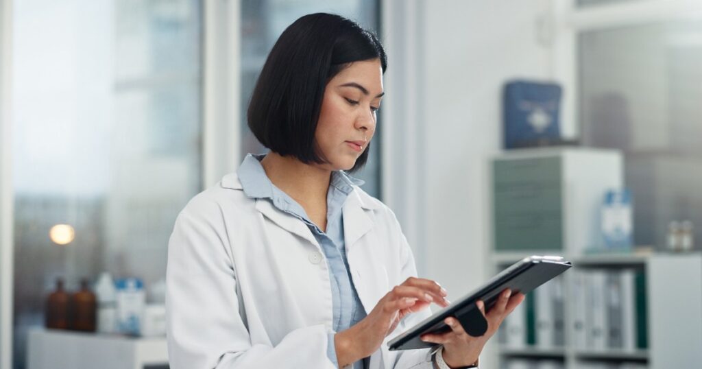 healthcare professional reviewing patient data on a tablet