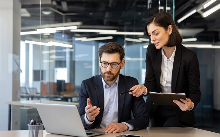 Insurance professionals reviewing performance metrics to improve operational efficiency and compliance
