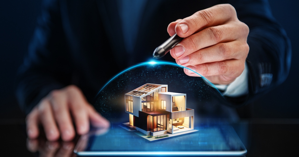 Businessman holding a pen over a miniature house on a tablet, representing insurance.