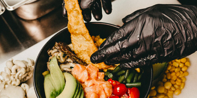 chef with black gloves making a salad