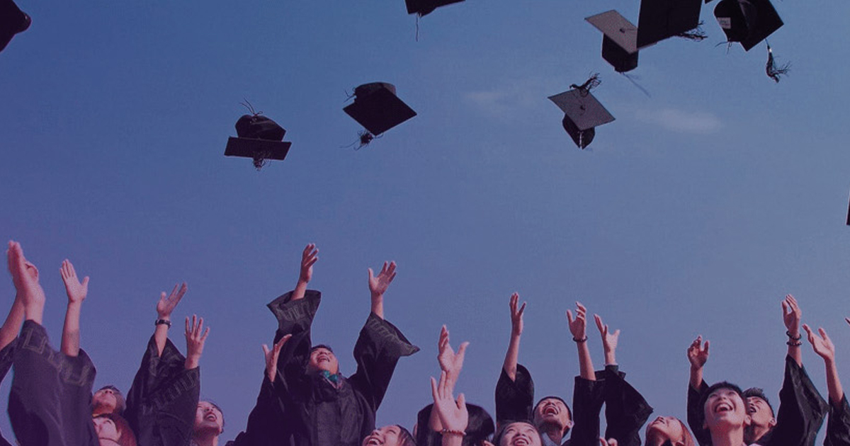Graduates throwing their caps into the sky, representing higher education overcoming challenges with platforms and automation.
