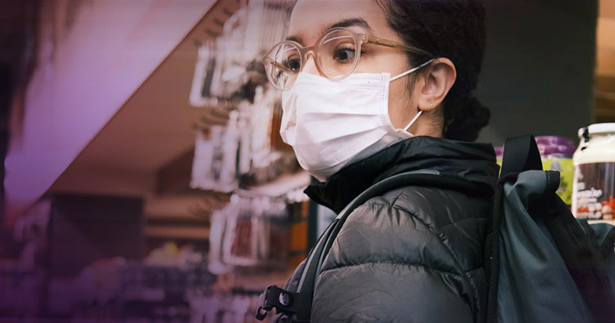 Person in glasses and a face mask browsing shelves in a store, representing the food industry adapting after COVID-19.