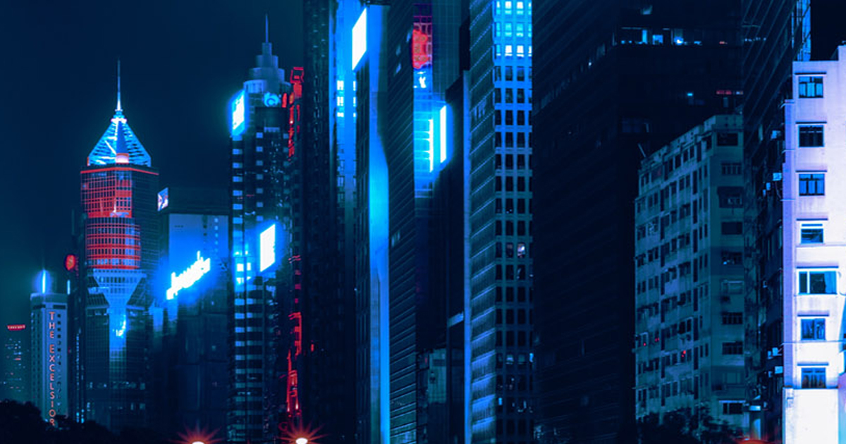 Futuristic skyline of neon-lit skyscrapers in blue and red, representing thriving in the DARQ world of emerging tech.