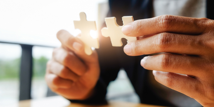 man joining two puzzle pieces