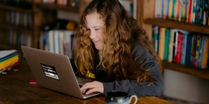 Young girl studying with a computer