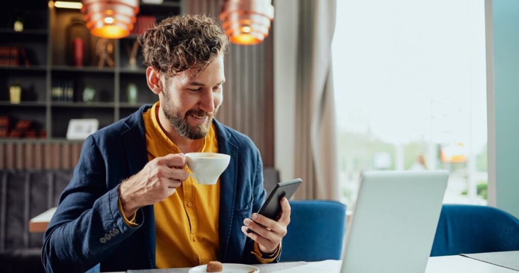 young man making a payment while having a coffee