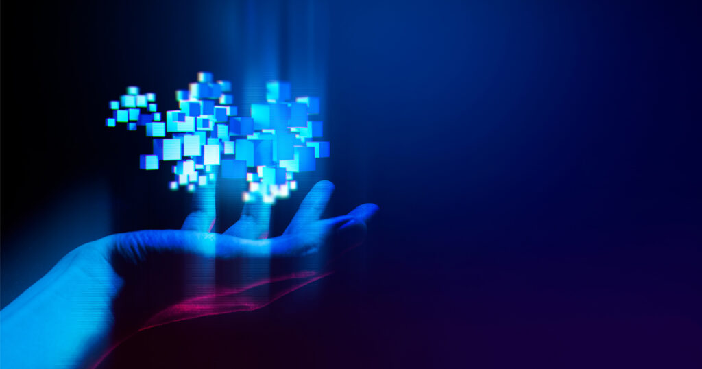 Hand holding a cluster of glowing digital cubes.